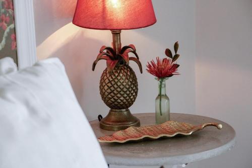 a table with a lamp and a vase with a pineapple on it at Villa Balthazar in Búzios