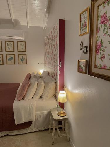 a bedroom with a bed and a table with a lamp at Villa Balthazar in Búzios