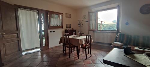 a living room with a table and chairs and a kitchen at PETTOCANNELLA in Massa e Cozzile