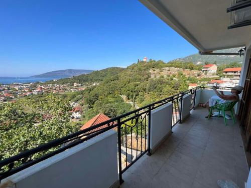 eine Person auf einem Stuhl auf einem Balkon mit Aussicht in der Unterkunft Stunning Adriatic Vista Home in Zelenika