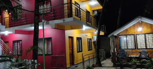 a house with colorful walls and windows at night at Rococo Pelton beach huts Palolem Beach goa in Palolem