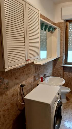 a bathroom with a sink and a washing machine at Casa Vacanze in Agliè