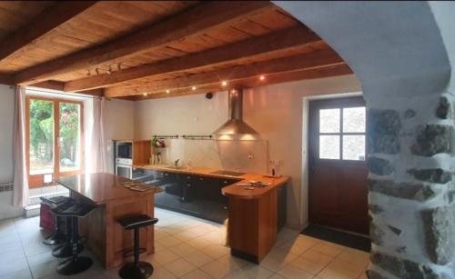 a kitchen with a table and a counter in a room at Lion-Les Jardins de Kuz in Bernin