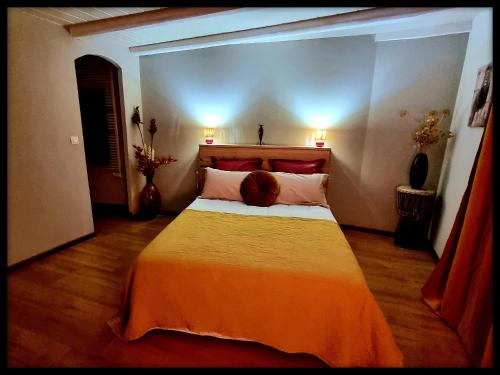 a bedroom with a large bed with two pillows at Lion-Les Jardins de Kuz in Bernin