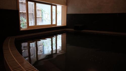 a house with a swimming pool with a window at Kobayashiya -Kinosaki Onsen- in Toyooka