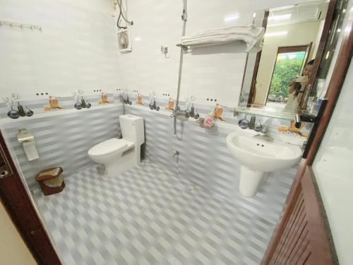 y baño con aseo y lavamanos. en Tre Xanh Homestay en Ninh Binh