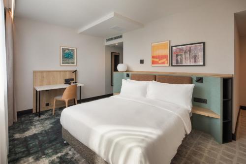a hotel room with a large bed and a desk at Crowne Plaza Budapest by IHG in Budapest