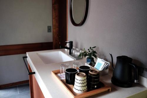 a bathroom counter with a sink and a tray with cups at Kobayashiya -Kinosaki Onsen- in Toyooka