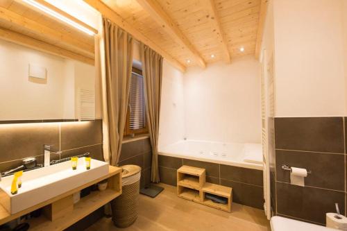 a bathroom with a sink and a bath tub at Haus Percha Mountain Apartments in Perca