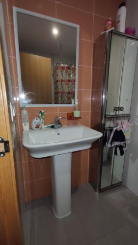 uma casa de banho com um lavatório branco e um espelho. em Habitación Doble em Benavites