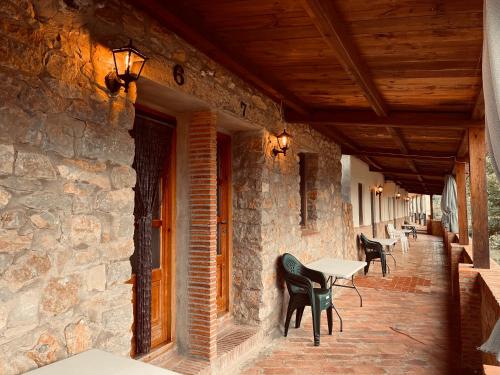 a patio with chairs and tables on a stone building at Complejo Rural La Glorieta in Catí