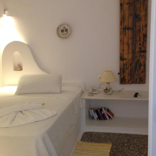 a bedroom with a bed and a table with a lamp at Bungalows Svoronos in Naousa