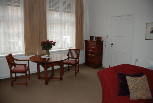 una sala de estar con mesa y sillas y una habitación con sofá en Vakantiehuis De Vorster Pastorie, en Broekhuizenvorst