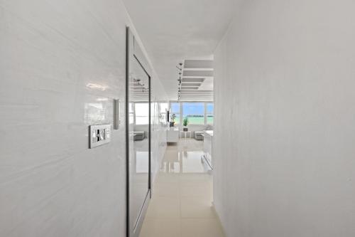 a hallway with white walls and a glass door at Amapola SeaSide Beach Front Apartment in San Juan