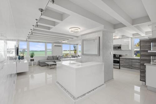 cocina blanca grande y sala de estar con fregadero en Amapola SeaSide Beach Front Apartment, en San Juan