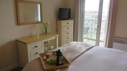 a bedroom with a bed with a tray of fruit on it at Citystay Living- Warren Close in Cambridge
