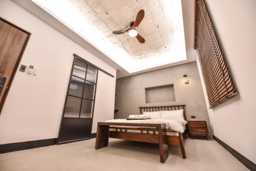 a bedroom with a bed and a ceiling fan at Eryang Homestay in Tainan