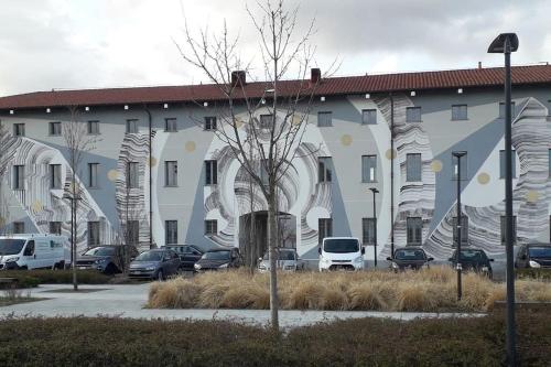 a large building with cars parked in a parking lot at SKYLINE MILANO Fiera in Milan