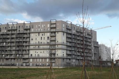 a large apartment building with trees in front of it at SKYLINE MILANO Fiera in Milan