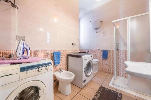 uma casa de banho com uma máquina de lavar roupa e um WC em Residenza Europa em Cagliari