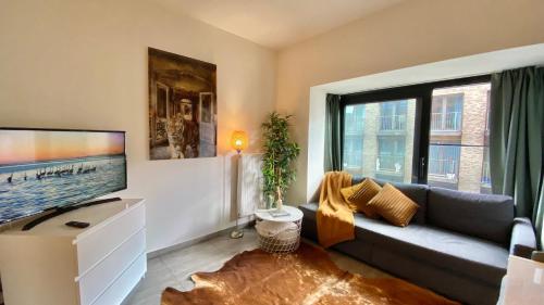 uma sala de estar com um sofá e uma televisão de ecrã plano em Oneluxstay Antwerp City Centre em Antuérpia