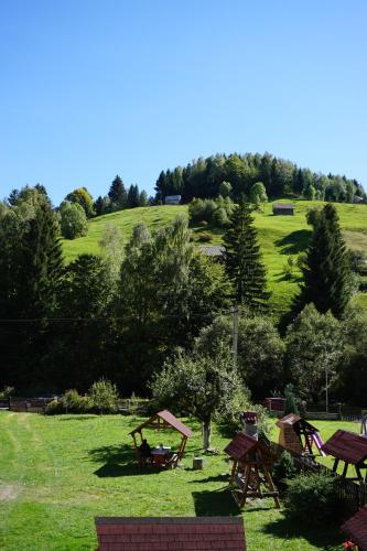 a group of picnic tables in a field of grass at Celestia in Moieciu de Sus