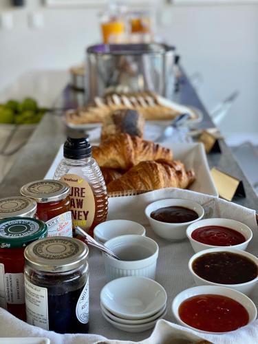 a table with a tray of bread and various condiments at Sea Five Boutique Hotel in Cape Town