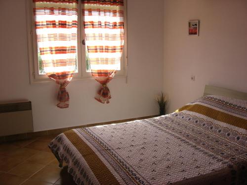 une chambre avec un lit et deux fenêtres dans l'établissement lumineux agréable T2 DE 32M2, à La Londe-les-Maures