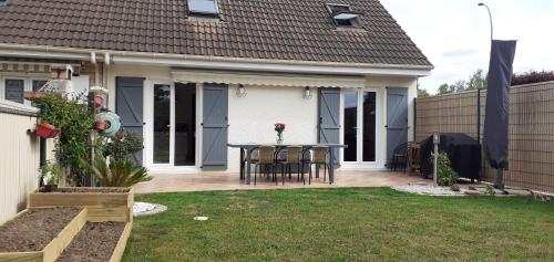 a house with a patio with a table and chairs at Maison au calme à proximité du circuit in Le Mans