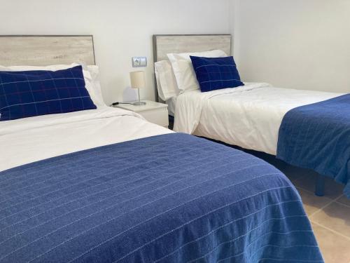 two beds in a room with blue and white at Las Brisas Mojacar Home in Mojácar