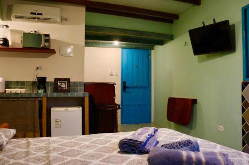 Habitación con cama y puerta azul en Estúdio dos sonhos com bela vista próximo ao alto da sé, en Olinda