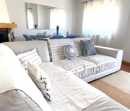 a living room with a white couch with pillows at Apartment Castelo Branco - Portugal in Castelo Branco