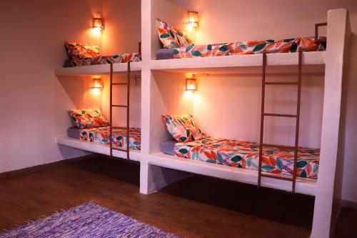 two bunk beds in a room with a rug at Santo Hostel in Porto Seguro
