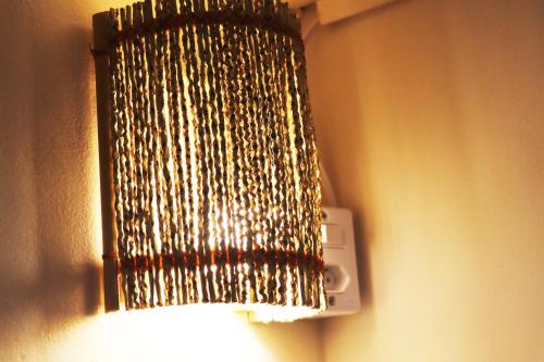 a chandelier hanging from a wall with a light at Santo Hostel in Porto Seguro