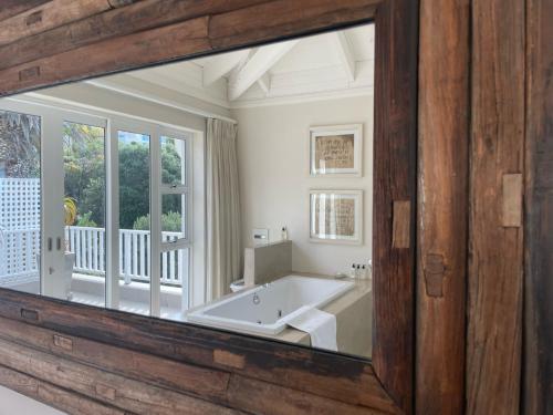 a bathroom with a tub and a large mirror at Sea Five Boutique Hotel in Cape Town