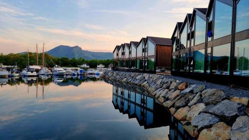 a marina with boats in the water next to a building at Ringstad Resort in Bø