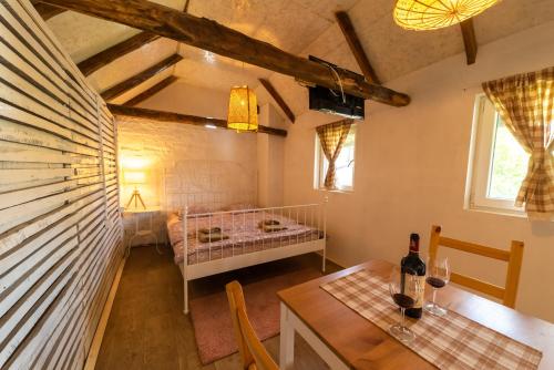 Zimmer mit einem Tisch und einem Bett in einem Zimmer in der Unterkunft Domacinstvo Cikic Zasavica in Zasavica