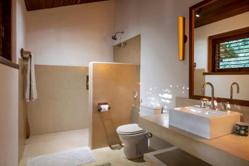 a bathroom with a sink and a toilet at Guest House - Praia de Itapororoca in Trancoso
