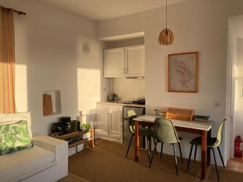 sala de estar con mesa y sillas y cocina en Alkyonis Sunset Suite, en Kamarai