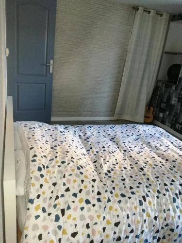 - une chambre dotée d'un lit avec un couvre-lit floral dans l'établissement à 2 pas du centre ville, à Parthenay