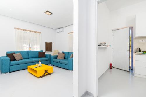 a living room with a blue couch and a yellow table at Blue Violet Apartment in Drios