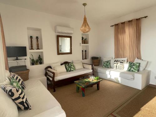ein Wohnzimmer mit 2 Sofas und einem Tisch in der Unterkunft Alkyonis Sunset Suite in Kamarai