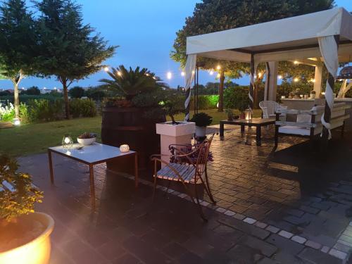 eine Terrasse mit einem weißen Baldachin sowie Tischen und Stühlen in der Unterkunft B&B Flavio e Catia in Marotta