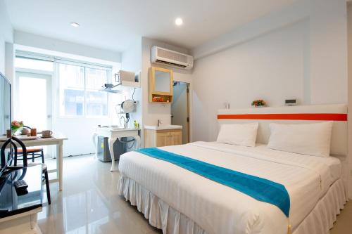 a bedroom with a large bed and a desk at Arawana Residence Phromphong in Khlong Toei
