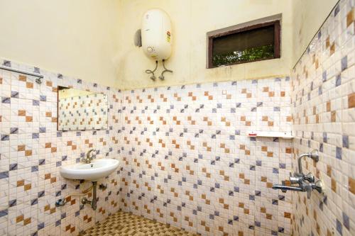 a tiled bathroom with a sink and a window at Aryan Riverside Camp, Panna Tiger Reserve, Madla in Panna