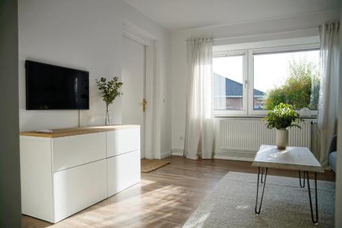 sala de estar con TV y armario blanco en Ferienhus #1 Nordfriesland, en Mildstedt