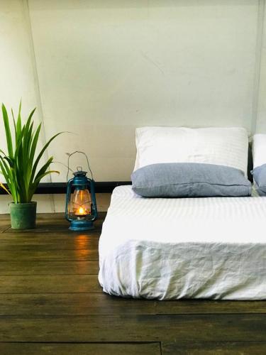 a bedroom with a bed and a lantern on the floor at Riverston Nature Villa in Rattota