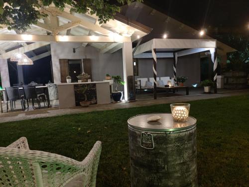 a patio with a table and chairs in a yard at night at B&B Flavio e Catia in Marotta