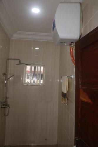 a bathroom with a shower and a window at Koring Residence at Dalaba Estate in Jabang