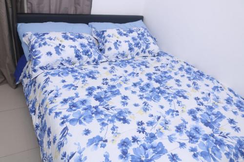 a bed with a blue and white comforter and pillows at Koring Residence at Dalaba Estate in Jabang